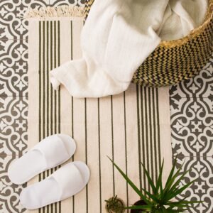 alfombra de baño con textiles del hogar, manta y zapatillas sobre suelo decorativo